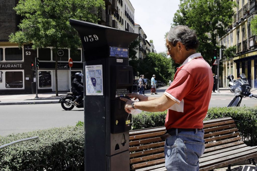 Un señor saca su ticket en la calle Santa Engracia