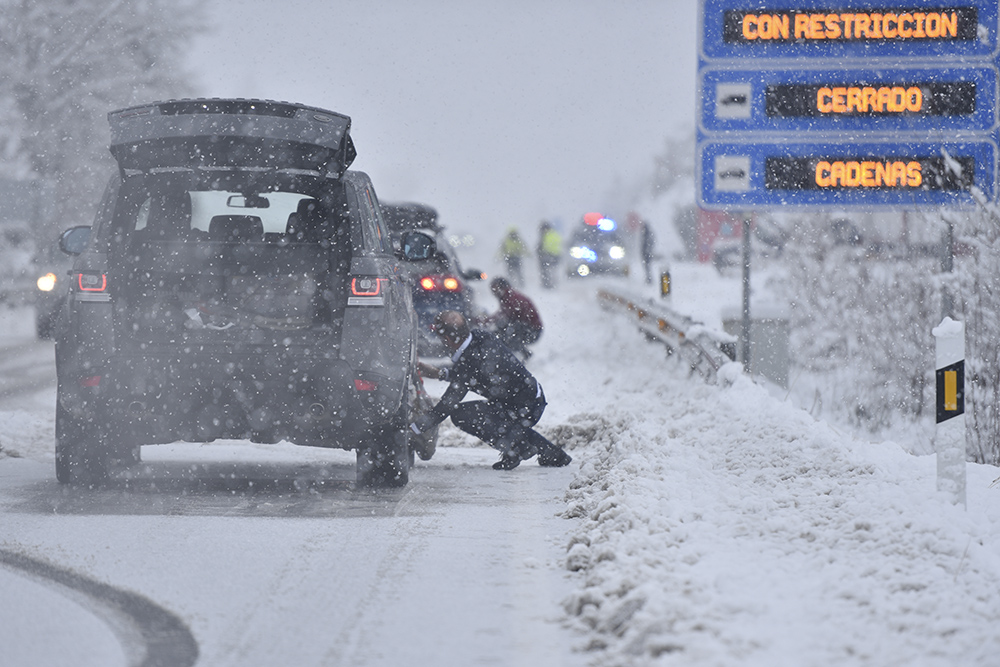 Personas ponen cadenas coches nieve Motor16