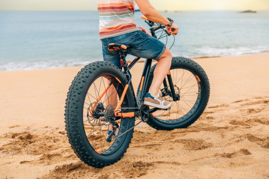 fat bike on the beach with guy riding on it Motor16