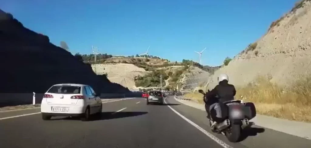 2025. Moto circulando por el arcén. Scooter. DGT. Imagen. motero