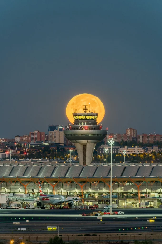 free photo of full moon behind air traffic control at madrid airport Motor16