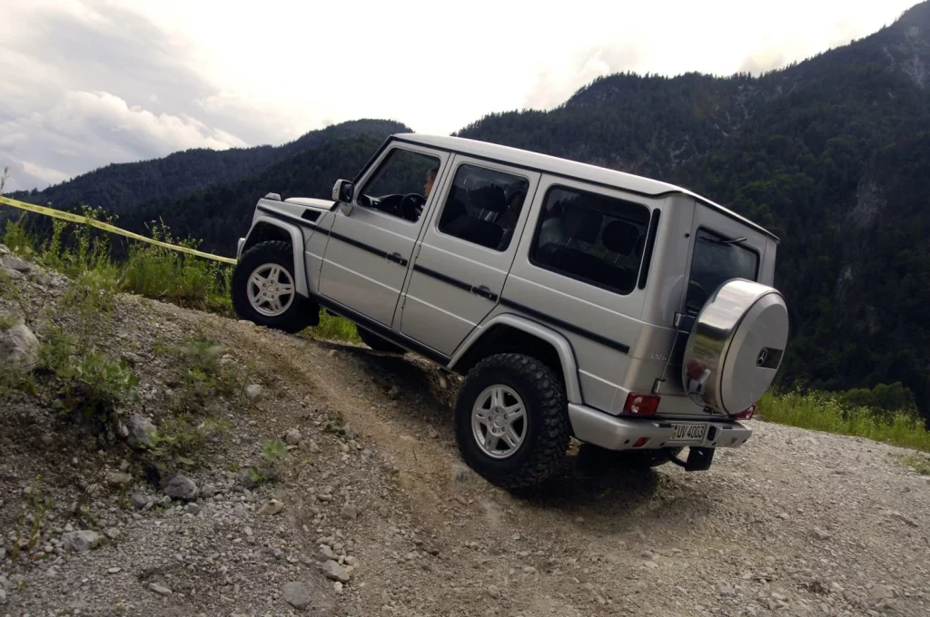 45 años de Mercedes Clase G: En 2006, el 320 CDI vuelve a revolucionarlo todo 1 Motor16 Nunca nos cansamos de repetir que una de las claves que ha mantenido vivo al Clase G (e incluso ha incrementado su atractivo) es su constante evolución y adaptación a los tiempos. En junio de 2006, Mercedes lanzaba una nueva actualización de su Clase G que incluía el reemplazo de sus dos diésel (270 CDI y 400 CDI) por el nuevo 320 CDI, el cual erogaba 224 CV y 540 Nm. Este nuevo salto tecnológico permitía a la casa alemana ofrecer un nivel de potencia equiparable al del diésel V8 con el consumo del popular modelo de cinco cilindros en línea, todo ello a pesar de equipar el restrictivo filtro de partículas diésel sin mantenimiento ni aditivos con el que cumplía con “los estrictos valores límite de emisiones de la norma EU4”, según comunicaba la compañía el 23 de junio de aquel año. Con la versión 320 CDI, el Clase G estrenaba un motor prodigioso El nuevo motor OM 642 de seis cilindros en V a 72º estaba fabricado íntegramente en aleación ligera. A pesar de que su nomenclatura sugería un cubicaje de 3,2 litros, lo cierto es que su cilindrada se limitaba a 2.987 cm3, algo que no le impedía ofrecer un elevado rendimiento. Para lograrlo, recurría a un sistema de inyección directa common rail de tercera generación con inyectores piezoeléctricos, distribución mediante cuatro válvulas por cilindro y un turbocompresor de geometría variable regulado eléctricamente. Solidario con su cigüeñal, el convertidor de par acoplaba una caja de cambios automática 7G-TRONIC de siete relaciones que suponía un importante avance respecto a los anteriores cambios de cinco marchas de cara no sólo a extraer más prestaciones de cada caballo, sino también para reducir los consumos y las emisiones. Por supuesto, no faltaban la caja tránsfer con reductora ni los tres diferenciales bloqueables. El nuevo motor se ofrecía en combinación con las tres versiones de carrocería disponibles entonces: los dos Station Wagon, con batalla corta y larga, y el Cabriolet con capota de accionamiento electrohidráulico Todas las versiones tenían en común un elevado nivel de equipamiento, que incluía de serie los faros bi-xenón, faros antiniebla con función de iluminación en curvas, anclajes Isofix para colocar sillas infantiles en las plazas traseras de forma cómoda y segura, una nueva gama de pinturas para la carrocería resistente a los arañazos en colores blanco calcita, verde periclase metalizado y azul teallite metalizado. El resistente paquete interior Artico (que incluía asientos y revestimientos de puertas tapizados en cuero sintético resistente y transpirable, así como un revestimiento para el piso fabricado en plástico robusto de fácil limpieza) estaba disponible como equipamiento opcional. El Clase G 320 CDI gastaba como un diésel y andaba como un gasolina… o mejor Con todo ello, el Clase G 320 CDI llegaba a los concesionarios entre septiembre y octubre de aquel año, y pronto demostraba sus cualidades, conformándose con un consumo de 11 l/100 km, acelerando de cero a 100 km/h en 8,8 segundos y alcanzando los 177 km/h. Su gama se completaba con los ya conocidos G 500, con motor V8 atmosférico de 296 CV, y G 55 AMG V8 KOMPRESSOR, con sus 476 CV, que en 2008 crecían hasta alcanzar la cifra de 500 CV. Pero, volviendo a 1986, muchas más cosas ocurrían en torno al siempre activo Clase G. A mediados de año, Mercedes comunicaba que el volumen total de producción de su todoterreno desde sus inicios (1979) hasta la fecha ascendía ya a 186.000 unidades. Paralelamente, los Clase G profesionales W461 adoptaban el nuevo V6 diésel como única mecánica de la gama, dando lugar a las versiones G 280 CDI, con un rendimiento rebajado a 184 CV y 400 Nm, disponibles entre 1.600 y 2.600 rpm.