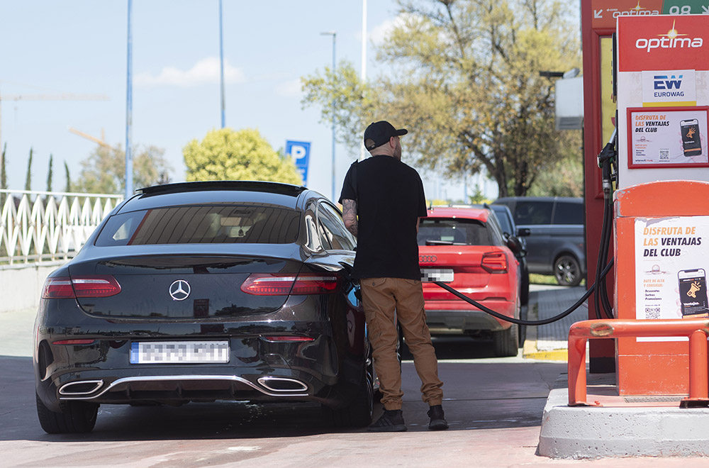 Un hombre reposta gasolina.