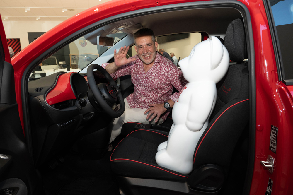 dEmo saluda desde el interior de un Fiat 500.