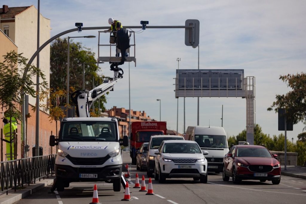 Un técnico monta las cámaras en los semáforos de Madrid.